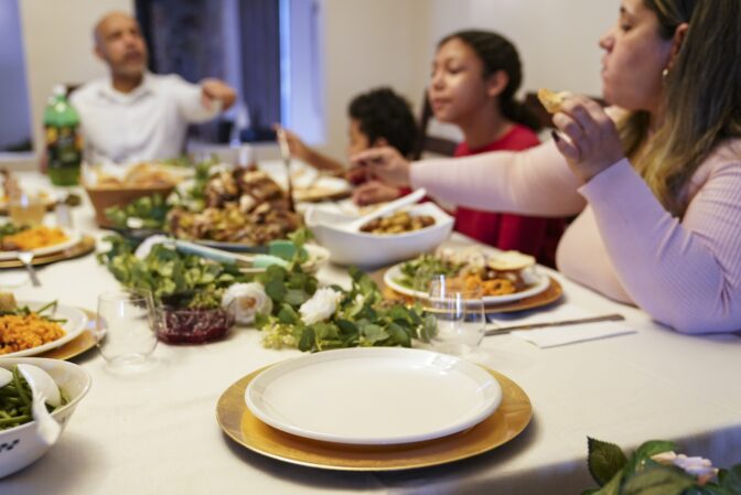 An empty place setting rests at the head of the dining room table for the recently deceased Ana Martinez, mother of Vivian Zayas and Alexa Martinez, during Thanksgiving dinner, Thursday, Nov. 26, 2020, in Deer Park, N.Y.