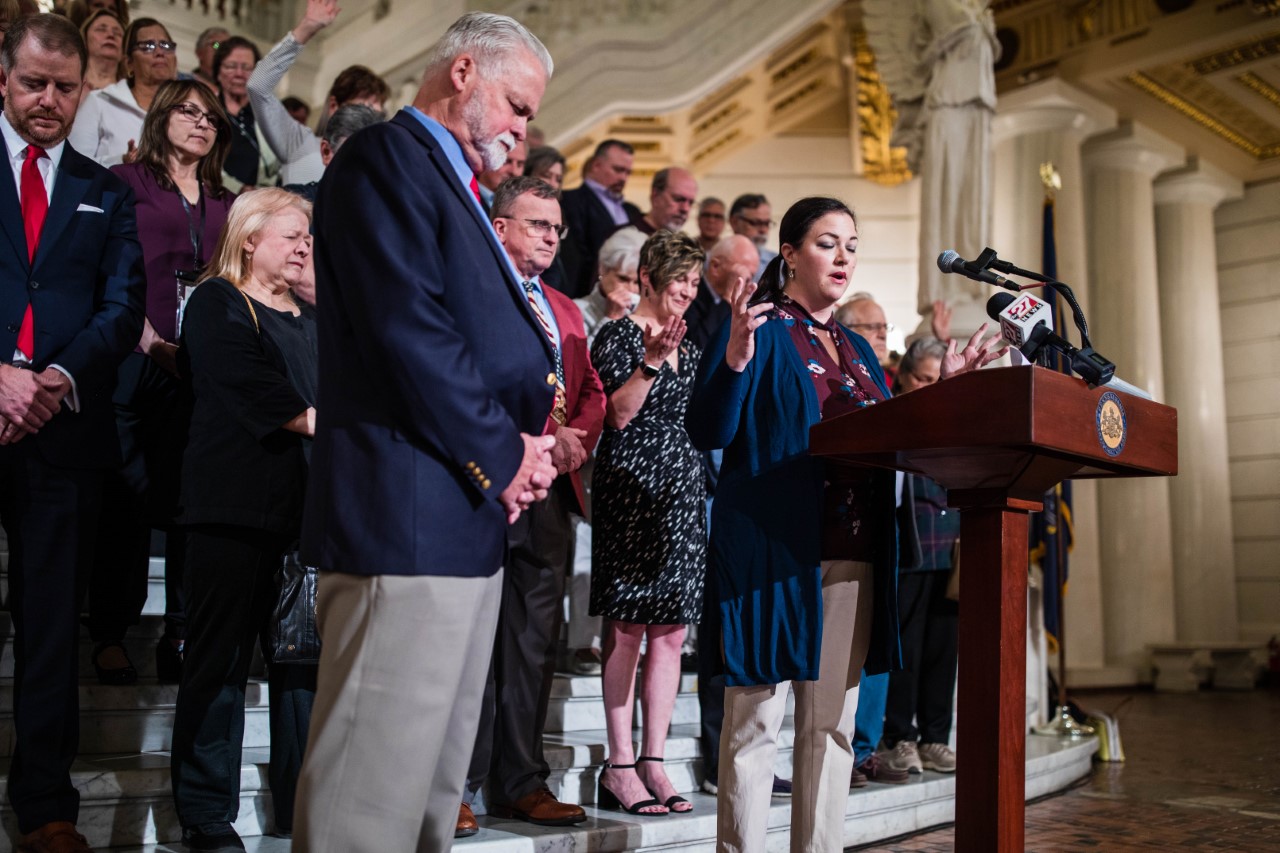 Toni Shuppe, co-founder of activist group Audit the Vote PA, leads a crowd in prayer at the state Capitol building in Harrisburg on May 11, 2022. The group had gathered to sign a document calling for Pa.'s no-excuse mail-in voting law to be repealed.