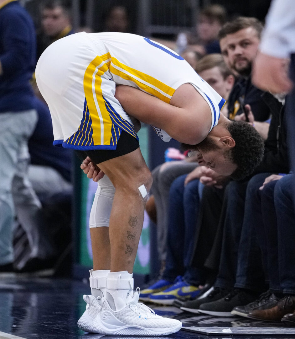 Golden State Warriors guard Stephen Curry (30) grabs his shoulder after after an injury during the second half of an NBA basketball game against the Indiana Pacers in Indianapolis, Wednesday, Dec. 14, 2022. The Pacers defeated the Warriors 125-119. (AP Photo/Michael Conroy)
