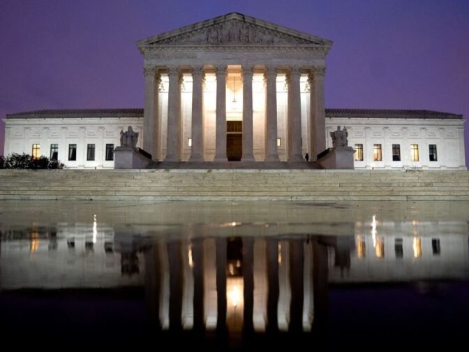 The US Supreme Court is reflected in a puddle of water in Washington, DC, on April 5, 2022.