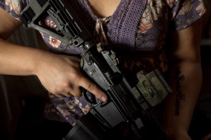 Mia Rose holds her custom-built AR-15 rifle in her home in Eugene, Ore.