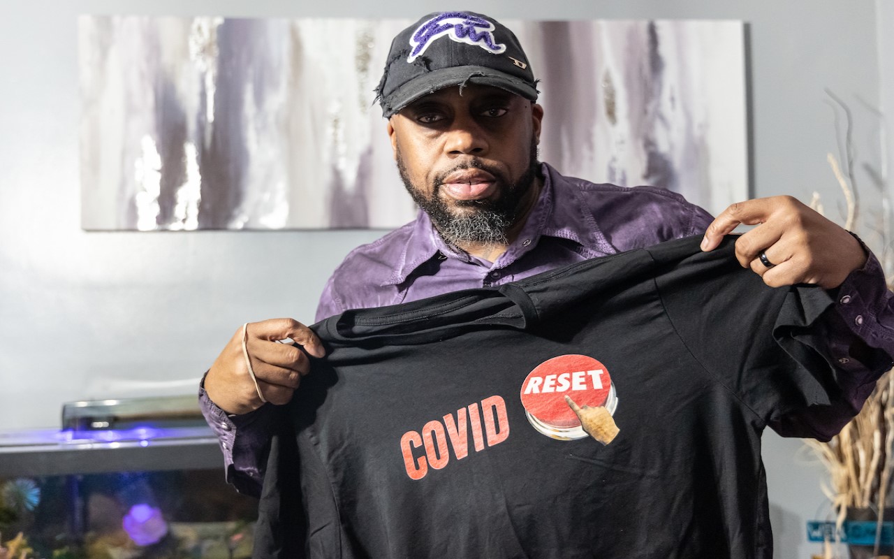 George Mink Jr. shows his COVID Reset t-shirt at his home in Delaware County, Pa. 