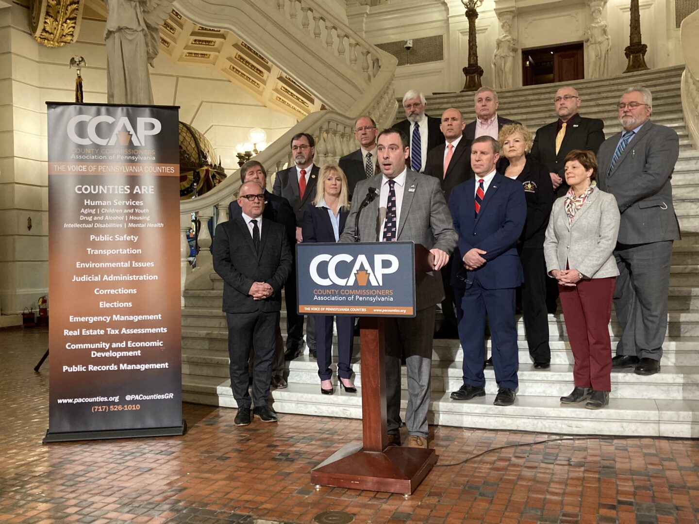 Pennsylvania County Commissioners Association President Chip Abramovic, surrounded by other county commissioners, speaks at a news conference in Harrisburg on January 25, 2023.