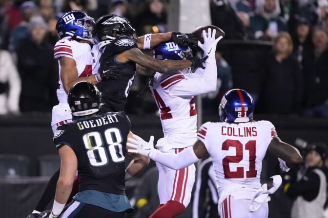 New York Giants safety Dane Belton, top right, intercepts a pass from Philadelphia Eagles quarterback Jalen Hurts, not visible, intended for wide receiver DeVonta Smith, top center, during the second half of an NFL football game, Sunday, Jan. 8, 2023, in Philadelphia.