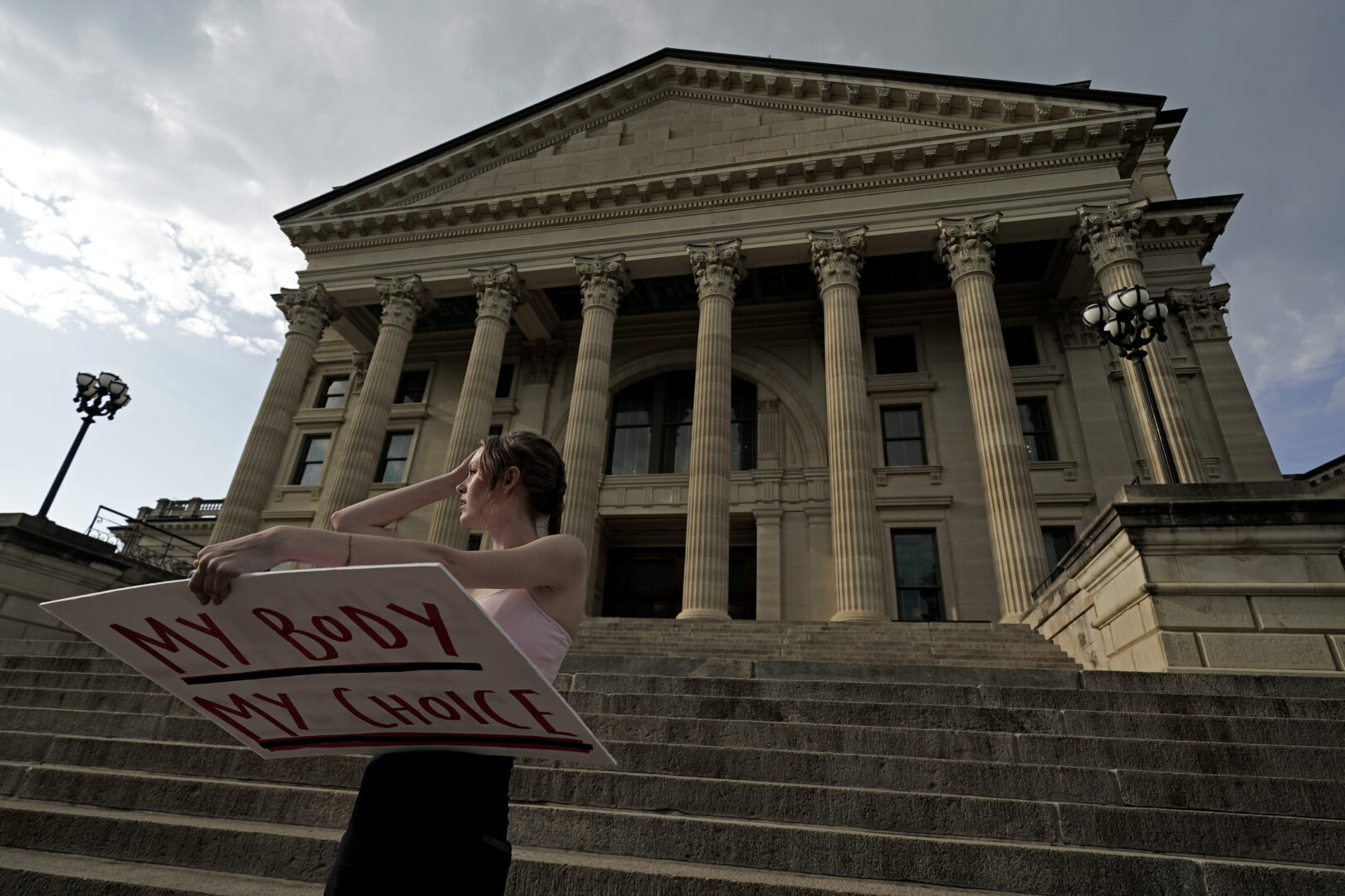 FILE - Zoe Schell, from Topeka, Kan., stands on the steps of the Kansas Statehouse during a rally to protest the Supreme Court's ruling on abortion June 24, 2022, in Topeka. Republicans and their anti-abortion allies, who suffered a series of defeats in ballot questions in states across the political spectrum in 2022, are changing tactics as new 2023 legislative sessions and the new election season start.