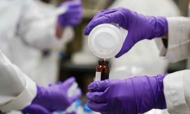 Eva Stebel, water researcher, pours a water sample into a smaller glass container for experimentation as part of drinking water and PFAS research at the U.S. Environmental Protection Agency Center For Environmental Solutions and Emergency Response, Thursday, Feb. 16, 2023, in Cincinnati. The Environmental Protection Agency is expected to propose restrictions on harmful "forever chemicals" in drinking water after finding they are dangerous in amounts so small as to be undetectable, but experts say removing them will cost billions.