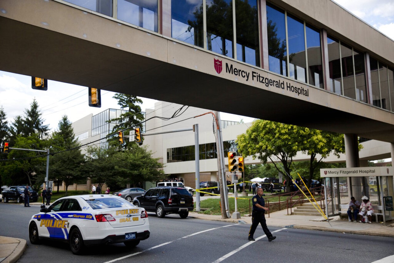 FILE--In this July 24, 2014 file photo, an officer walks near the scene of a shooting at Mercy Fitzgerald Hospital in Darby, Pa.  The deadly shooting at the suburban Philadelphia hospital is serving as yet another illustration of the hazards mental health professionals face on the job, and, experts say, the need for hospitals to do more to protect them.  