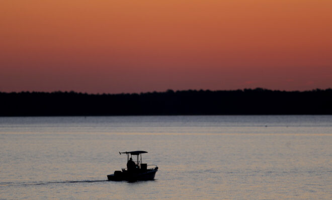 FILE - A small boat travels along the Honga River near the Chesapeake Bay, as the sky lights up at sunrise in Fishing Creek, Md., May 14, 2020. A report on the Chesapeake Bay released Tuesday, June 6, 2023, found strong disparities between communities in different parts of the bay's watershed in terms of health, economics and social justice concerns, presenting the challenges of improving the health of the nation's largest estuary in a larger context. 