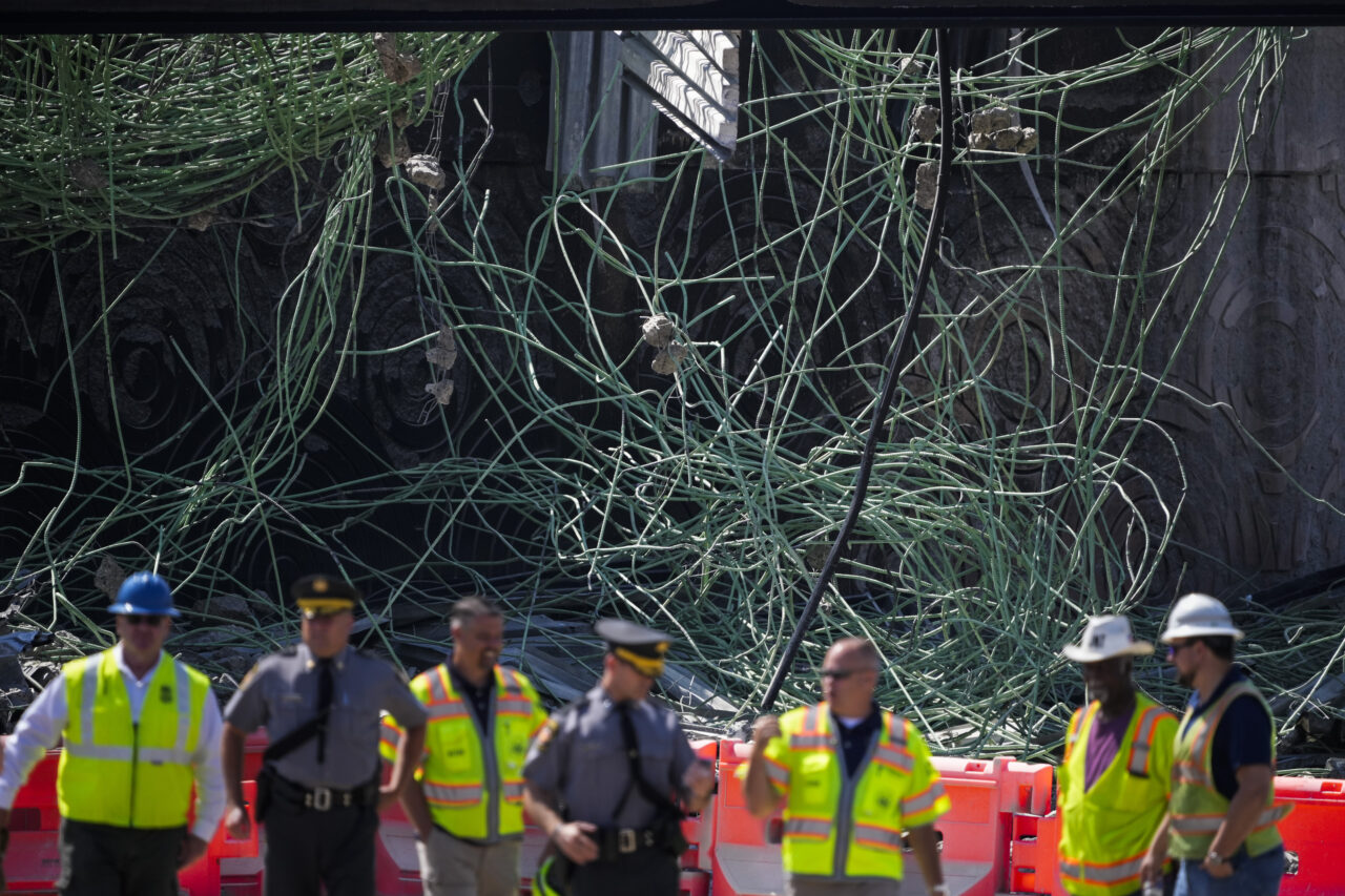 Officials gather ahead of Transportation Secretary Pete Buttigieg's expected visit to the scene of a collapsed elevated section of Interstate 95, in Philadelphia, Tuesday, June 13, 2023. (AP Photo/Matt Slocum)