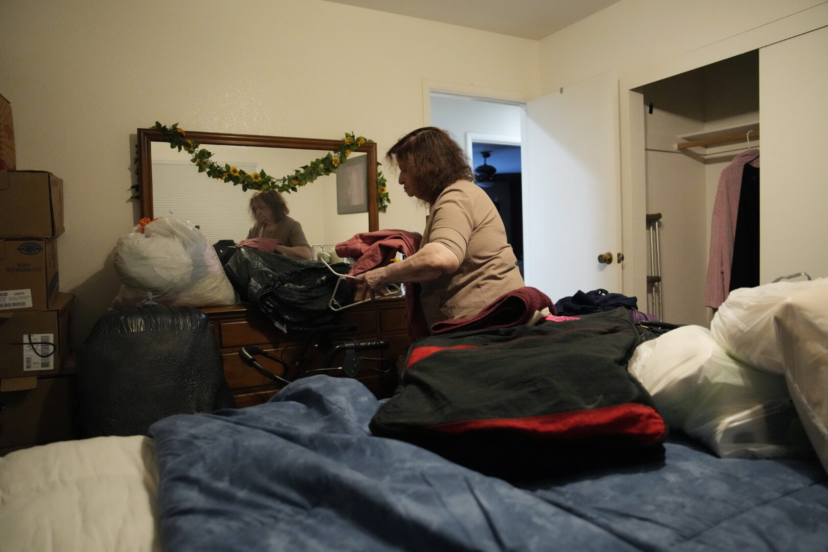 Maria Jackson unpacks clothes into a room she is renting Monday, May 8, 2023, in Las Vegas. Jackson, a longtime massage therapist, lost her customers when the pandemic triggered a statewide shutdown in March 2020 and was evicted from her apartment earlier this year. (AP Photo/John Locher)