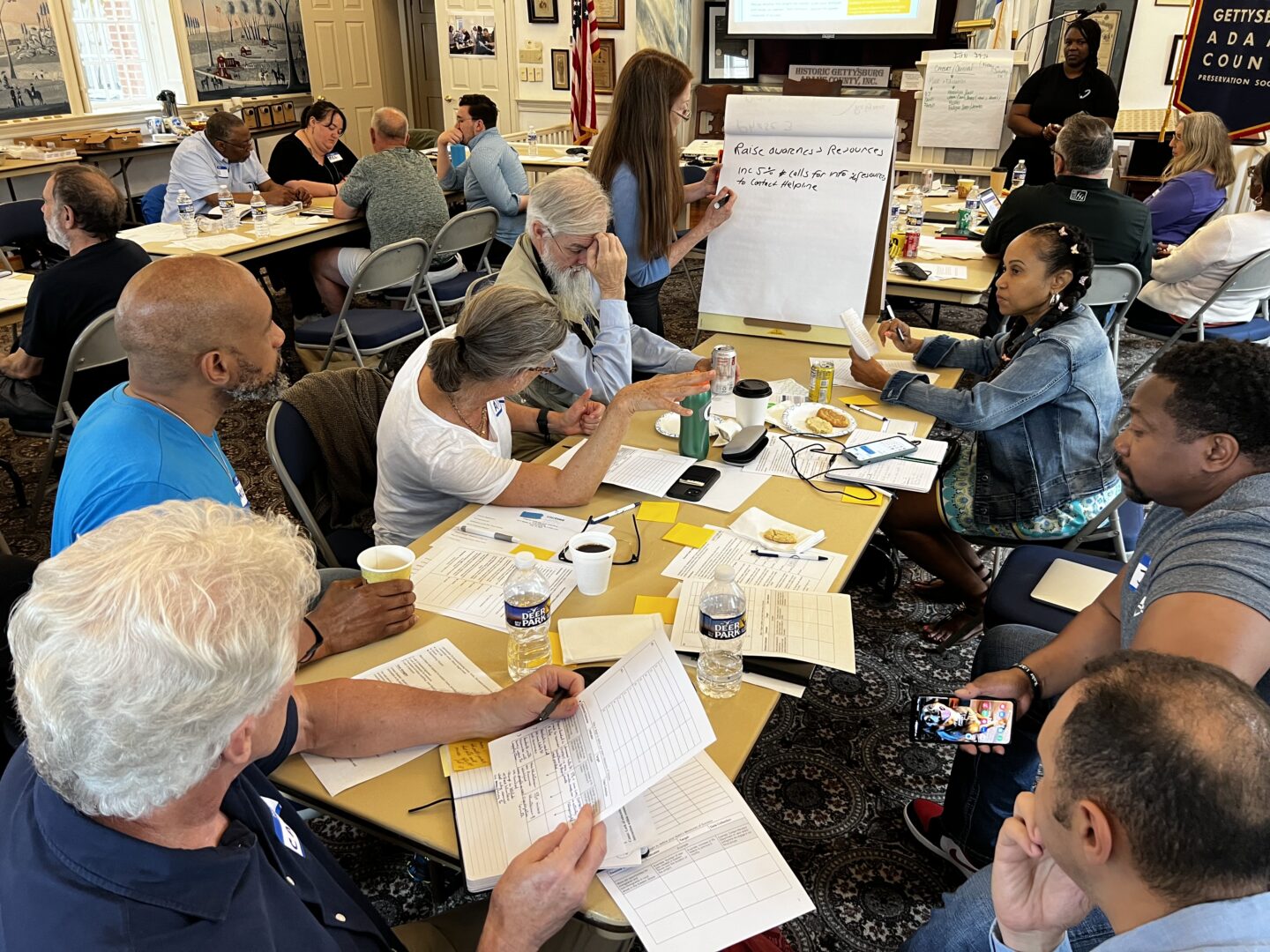 Uniting to Prevent Targeted Violence group members discussing plans to enhance the social services in their communities during a meeting on May 13, 2023. 
