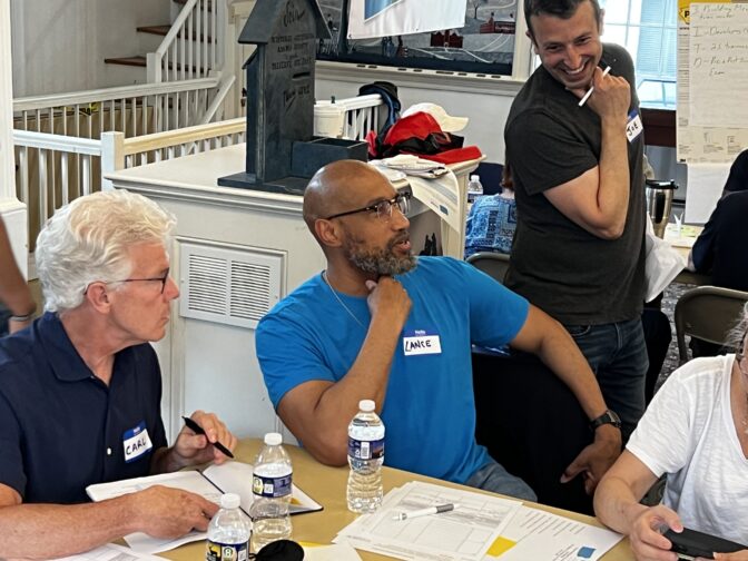 UPTV group members Carl Helman (left) and Lance Walker (middle) talk with Urban Rural Action founder Joe Bubman (right) about ways to combat identity-based violence in their communities on May 13, 2023. (Robby Brod)