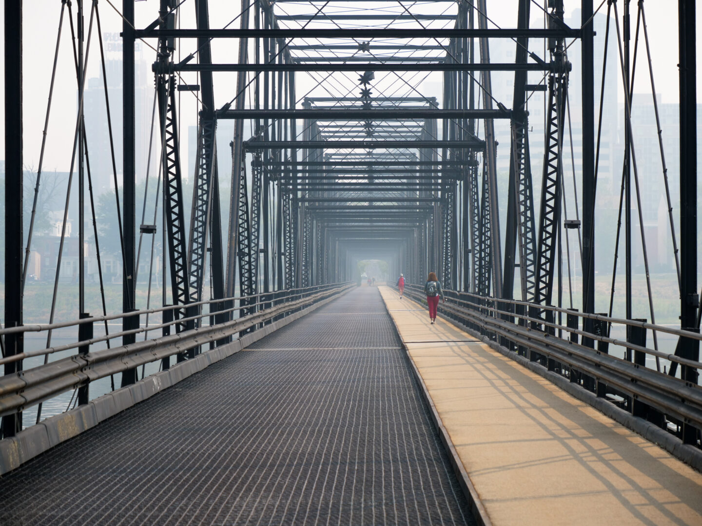 People walk towards Harrisburg on the Walnut Street Bridge as haze hangs over Harrisburg as smoke from Canadian wildfires filtered into Pennsylvania on June 8, 2023. The smoke degraded air quality across Pennsylvania and other states in the northeast. 