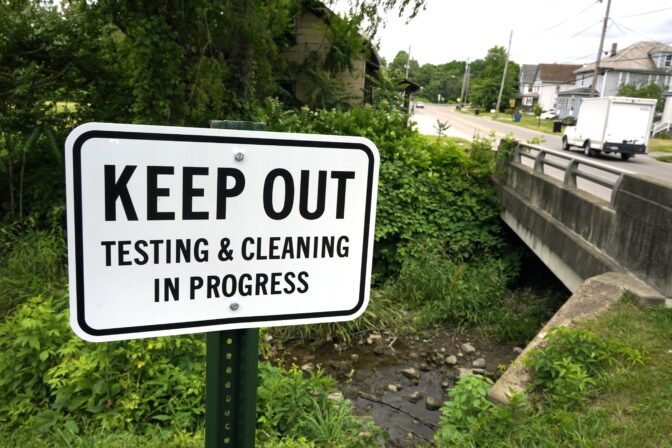 A warning sign is posted near a stream in East Palestine Park in East Palestine, Ohio on Thursday, June 22, 2023.