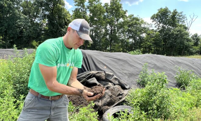 Will Brownback, owner of Spiral Path Farm, unwraps compost curing that is to be spread on his fields in the spring of 2024. Adding organic matter improves soil health and helps to mitigate climate change.