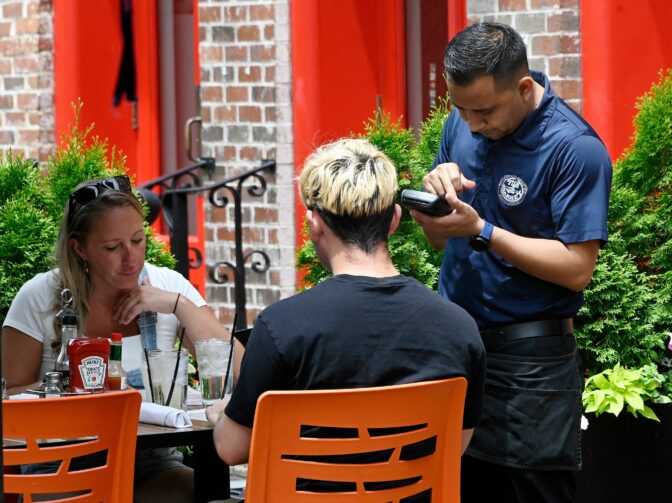 A waiter works at a restaurant in Alexandria, Virginia, on June 3, 2022. - US employers added 390,000 jobs last month, the US Labor Department reported on June 3, 2022, a sign of a slowdown in hiring but still a better-than-expected result. Restaurants and hotels that were decimated due to Covid-19 showed a strong recovery in May, adding 84,000 positions, the data showed. 