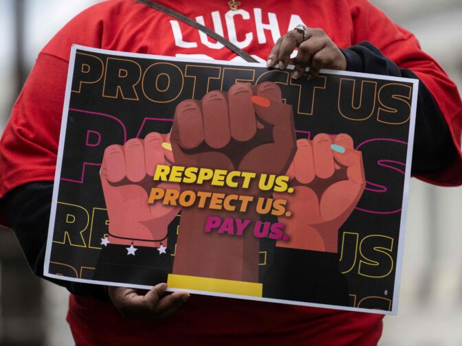 A person holds a sign as US Senator and Health, Education, Labor and Pensions Chairman Bernie Sanders (I-VT), not pictured, speaks during a news conference with labor leaders to make an announcement on the federal minimum wage, on Capitol Hill in Washington, DC, on May 4, 2023.