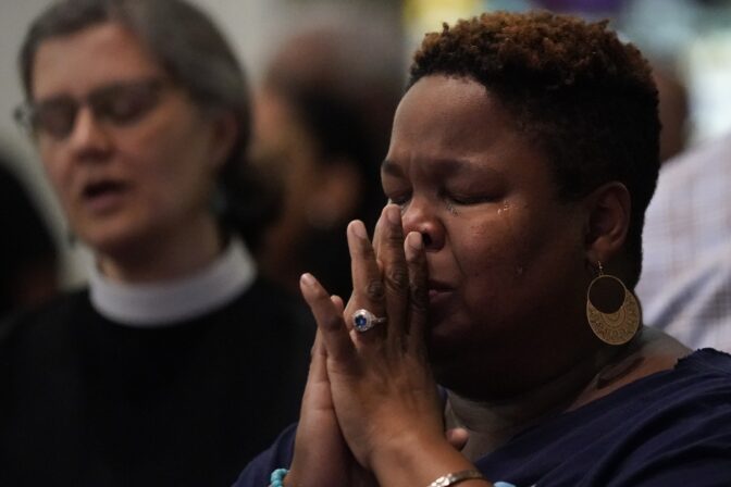 A woman cries while singing at a prayer vigil at Salt and Light church for the victims of a fatal shooting spree, Wednesday, July 5, 2023, in Philadelphia.