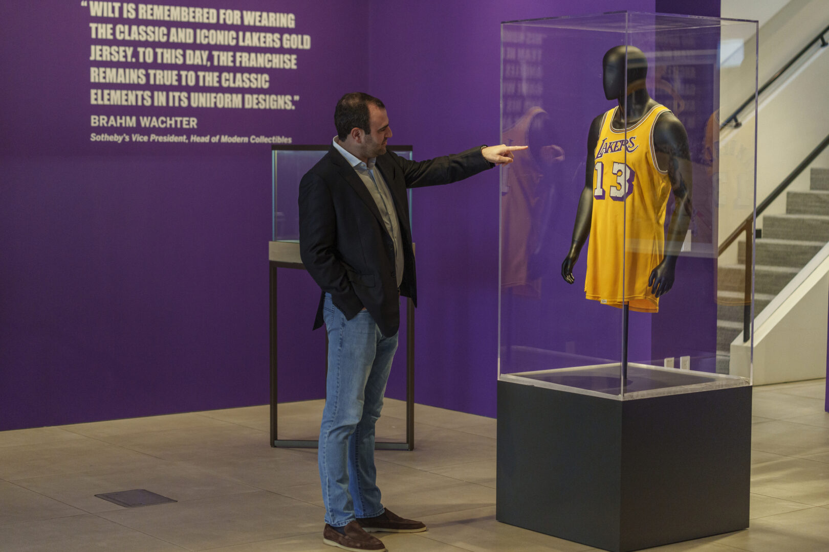 Sotheby's Vice President Brahm Wachter looks at the display of Wilt Chamberlain's 1972 NBA Finals 'Championship Clinching' Jersey at Sotheby's Los Angeles Gallery on Tuesday, Aug. 1, 2023, in Beverly Hills, Calif. The jersey is being offered along with a collection of memorabilia in an online sale Aug. 28-Sept. 27.  