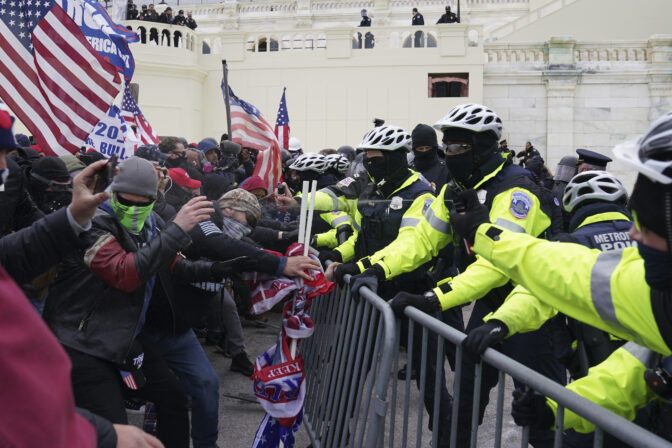 Rioters loyal to President Donald Trump clash with police at the U.S. Capitol on Jan. 6, 2021, in Washington. Liberal groups are trying to end Trump's attempt to return to the White House by arguing that he is no longer eligible to be president after trying to overturn the 2020 election results