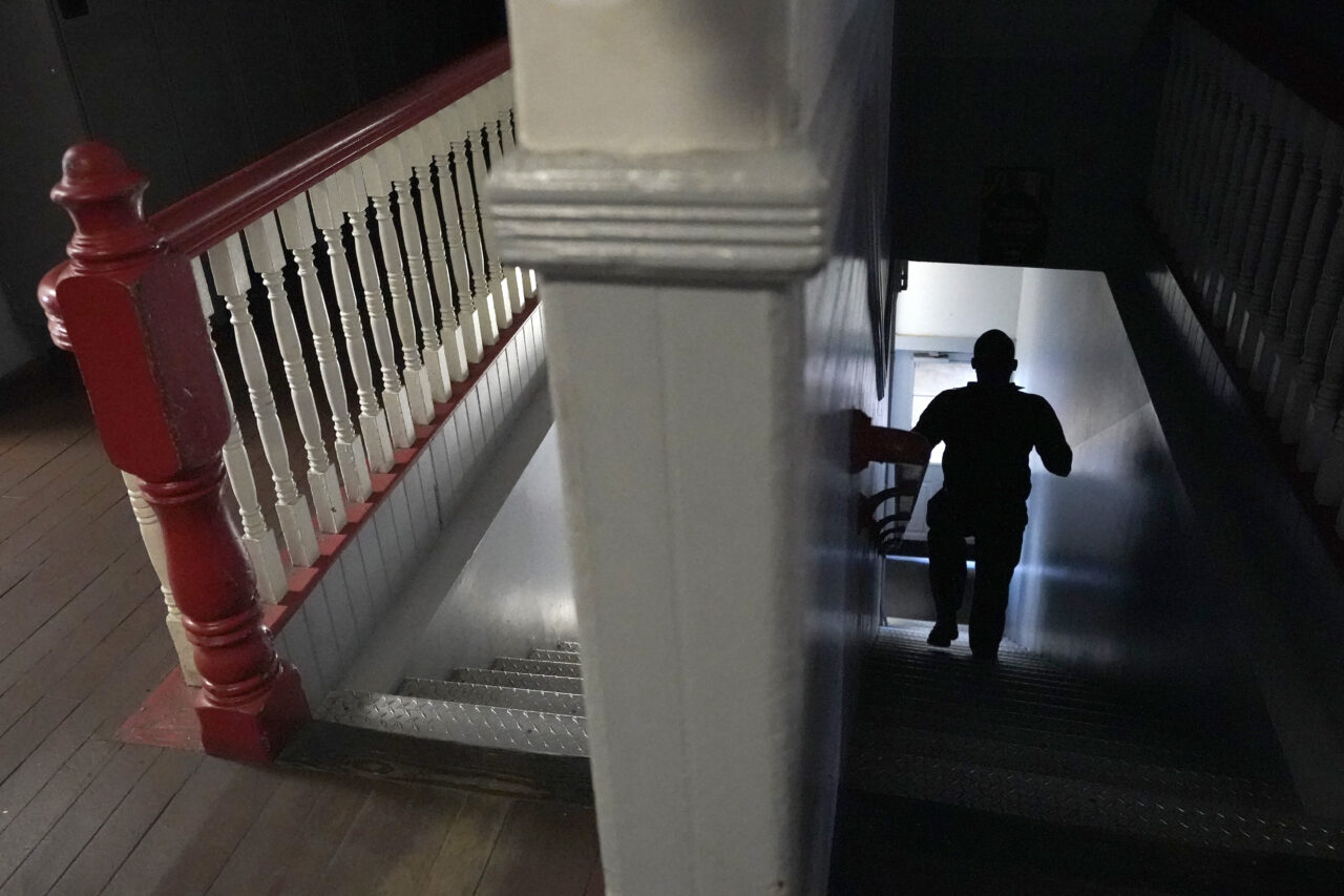 A Brockton firefighter walks down a flight of stairs at Station 1, Thursday, Aug. 3, 2023, in Brockton, Mass. Firefighters around the country are concerned that gear laced with the toxic industrial compound PFAS could be one reason why cancer rates among their ranks are rising. The chemical, which has been linked to health problems including several types of cancer, is used in turnout gear to repel water and other substances when fighting a fire. (AP Photo/Steven Senne)