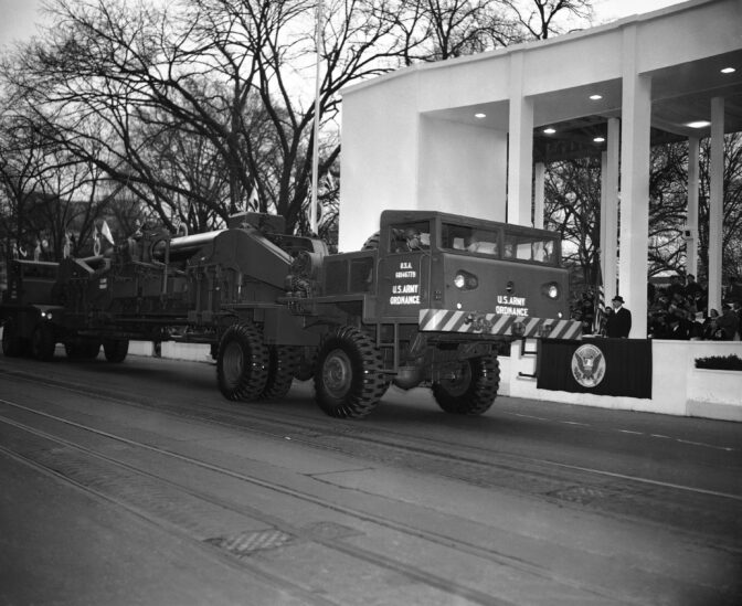 The Army's 85-ten atomic cannon is hauled past the Presidential reviewing stand during the Inaugural Parade for Pres. Dwight Eisenhower, at right, Jan. 20, 1953, Washington, D.C. At right, Pres. Eisenhower gets a first hand look at the awesome weapon which can throw a shell 20 miles. So big is the artillery piece it has to be driven from both ends. In weights 85 tons. (AP Photo)