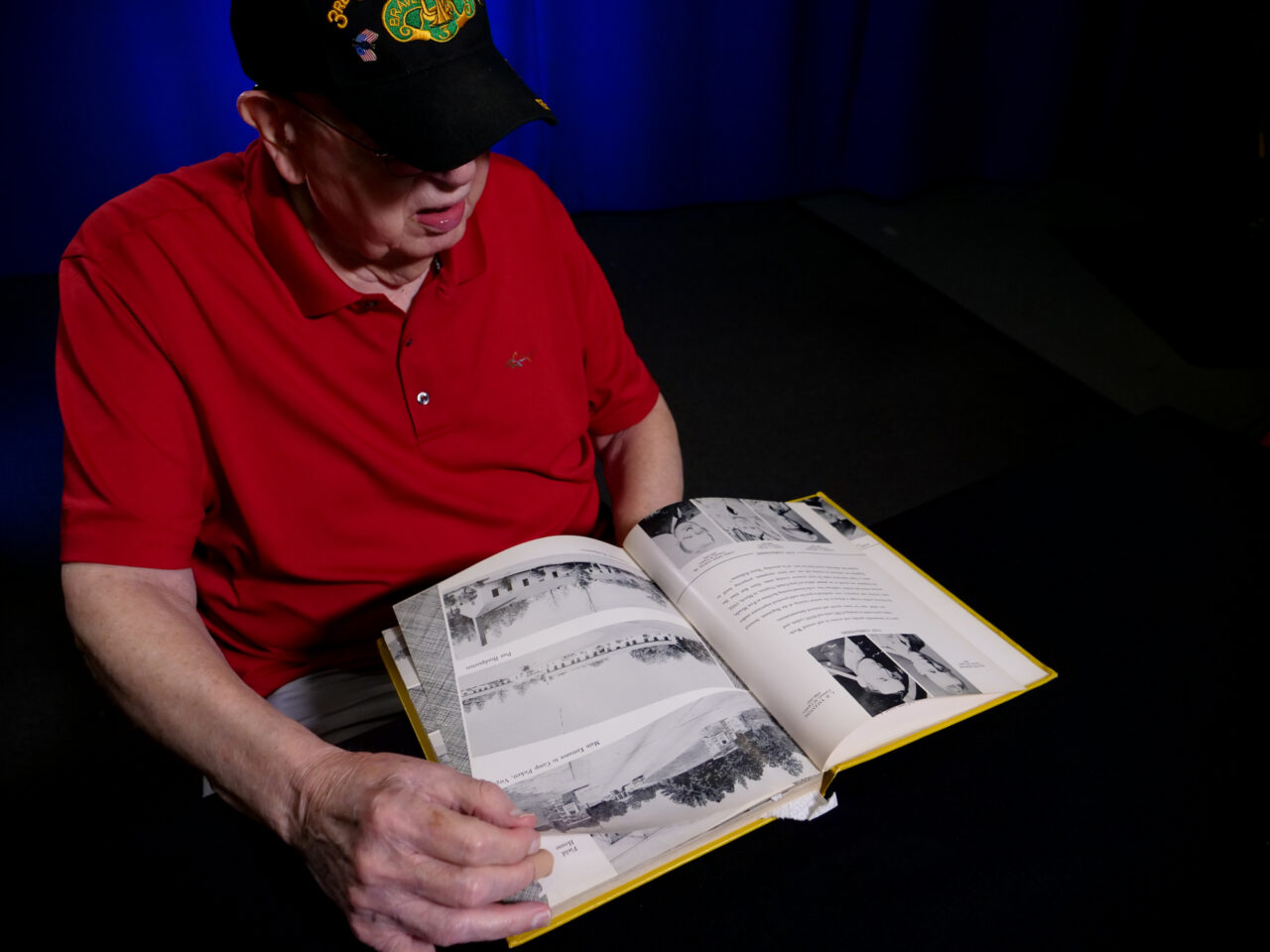 Tom Lambert looks through his unit's yearbook. (Jeremy Long - WITF)