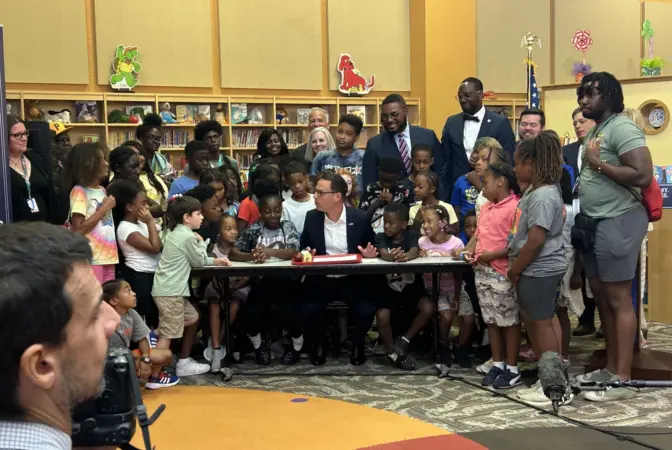 Gov. Josh Shapiro ceremonially signs legislation funding the universal free breakfast program alongside students and staff in Penn Hills on Tuesday, Aug. 8, 2023.