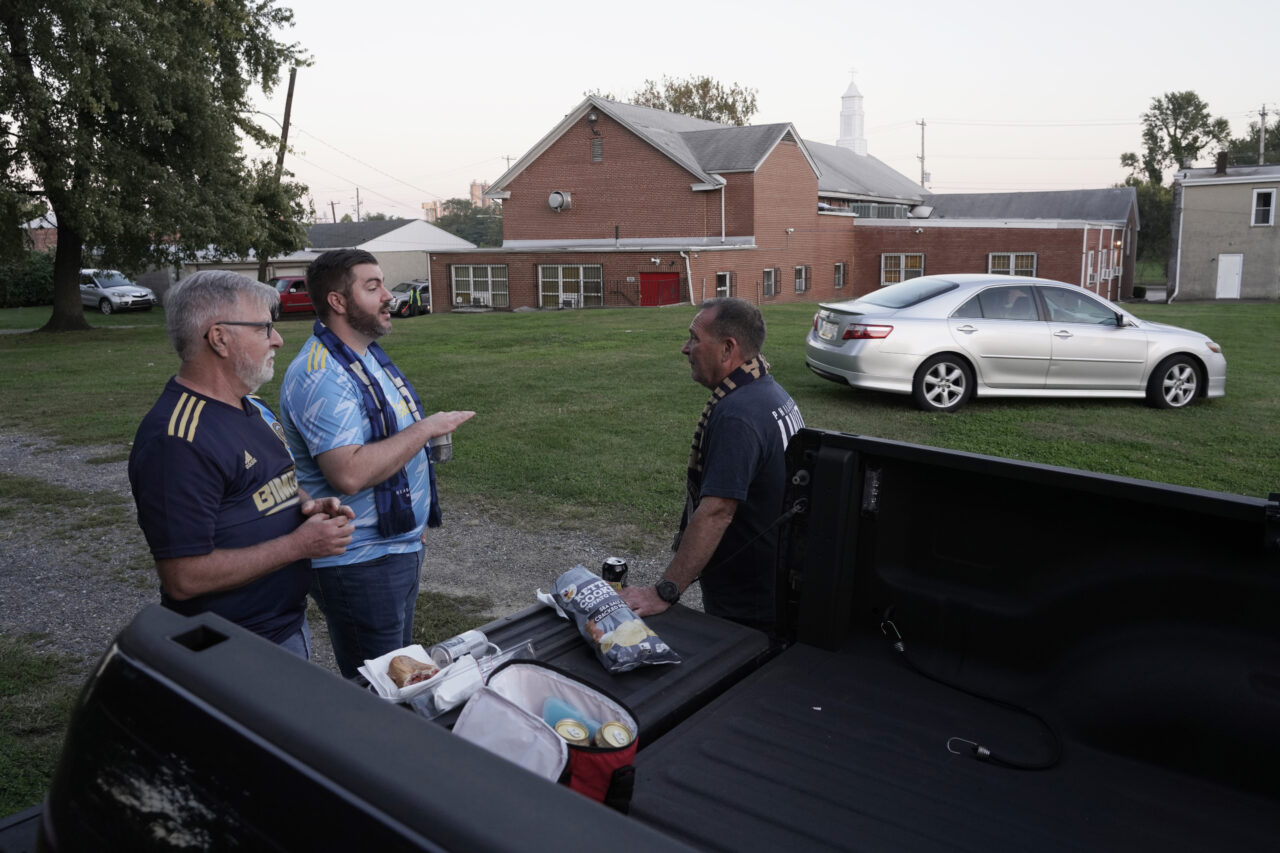 From left, Rich Kaeble, Rick Kaeble and Marty Hackett tailgate at the Calvary Baptist Church parking lot which is located near the Philadelphia Union's Subaru Park, Wednesday, Oct. 4, 2023, in Chester, Pa. Jeffrey Scholes, co-author of “Religion and Sports in American Culture,” said churches like Calvary show a growing willingness to use “secular entities like sport for religious purposes” including, “continuing a ministry, feeding the poor, keeping the lights on, things that ideally churches do." (AP Photo/Michael Perez)