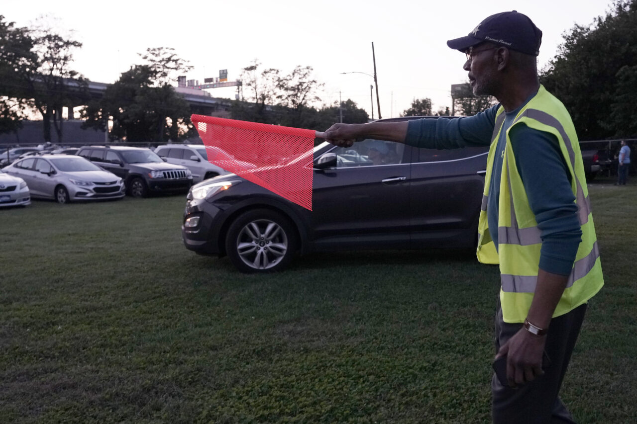 Reginald Rawls directs a vehicle into a spot at the Calvary Baptist Church parking lot which is located near the Philadelphia Union's Subaru Park, Wednesday, Oct. 4, 2023, in Chester, Pa. (AP Photo/Michael Perez)