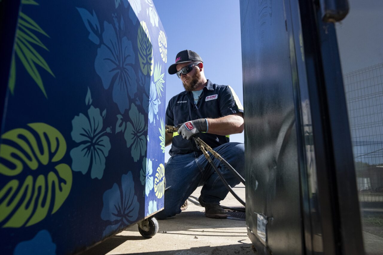 An operator attaches equipment to a used appliance at a customer recovery job site, Monday, Oct. 9, 2023, in Little Elm, Texas. The company A-Gas takes in shipments of refrigerators and tanks from around the country and beyond, drains them, then purifies and reclaims the chemicals, shipping out recycled product. This prevents the need for new chemical production. (AP Photo/Sam Hodde)