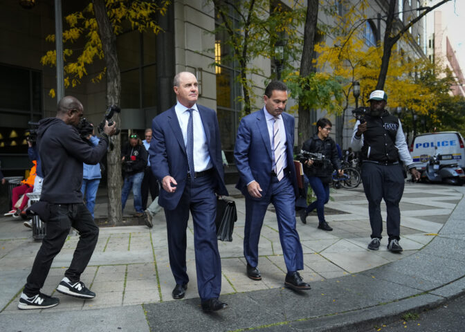 Defense attorneys Brian McMonigle, left, and Fortunato Perri walk from the criminal justice center in Philadelphia after a judge has reinstated all charges, including a murder count, against their client former police officer Mark Dial, Wednesday, Oct. 25, 2023. Dial on Aug. 14, shot and killed Eddie Irizarry during a during a traffic stop. (AP Photo/Matt Rourke)