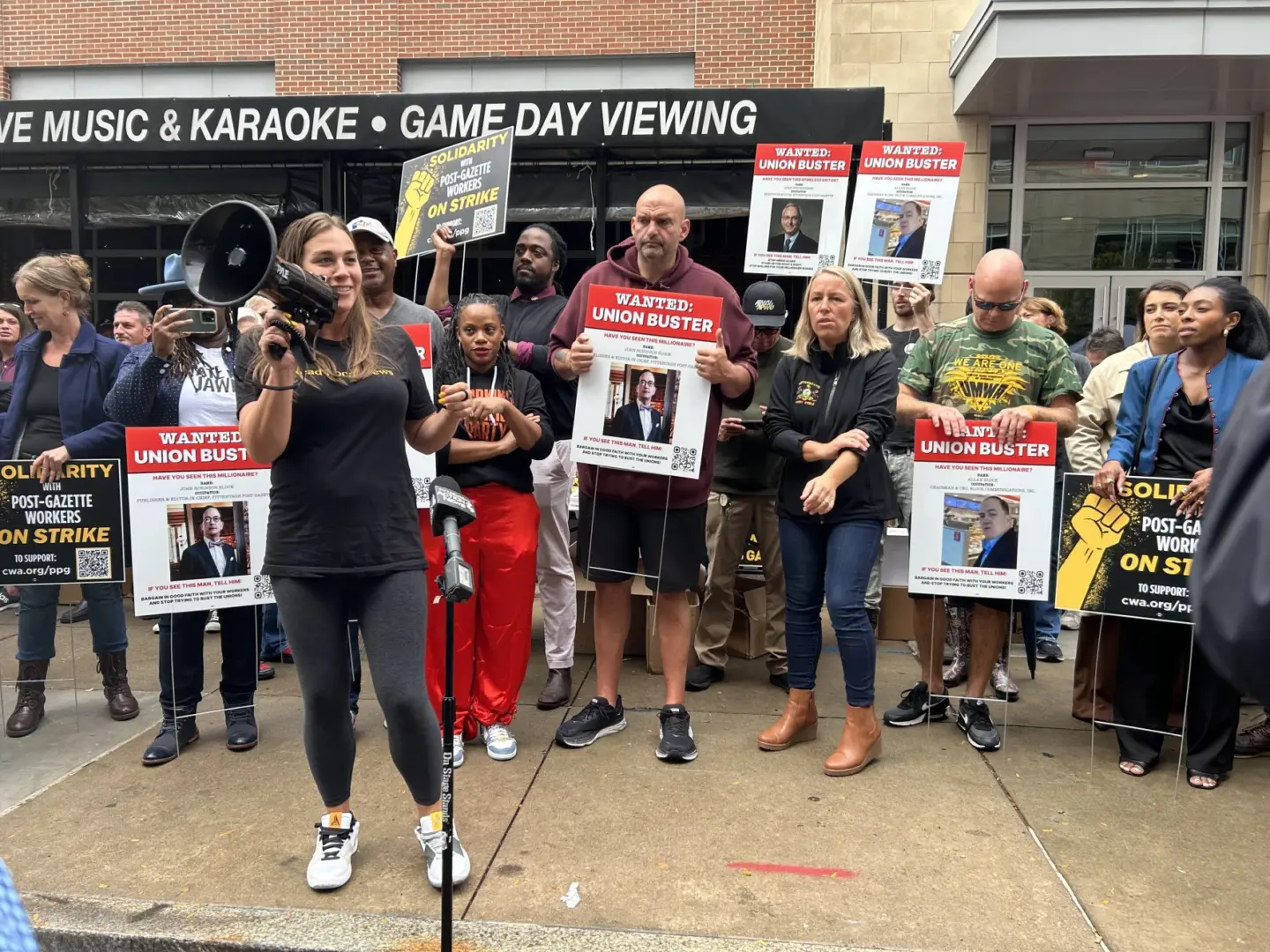 Elected leaders, including county councilor Bethany Hallam and U.S. Sen. John Fetterman, rally on Oct. 6 outside the Pittsburgh Post-Gazette's North Shore offices.
