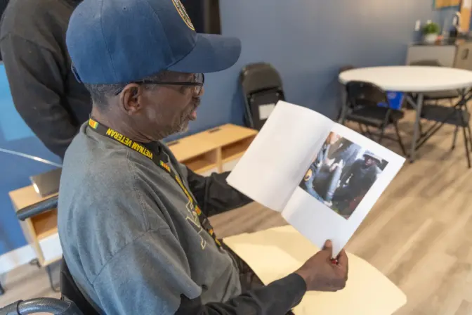 Vietnam War veteran Leon Brantley holds an image of himself with artillery during his military training in Hawaii in the community room at Veterans Village in Northeast Philadelphia. 