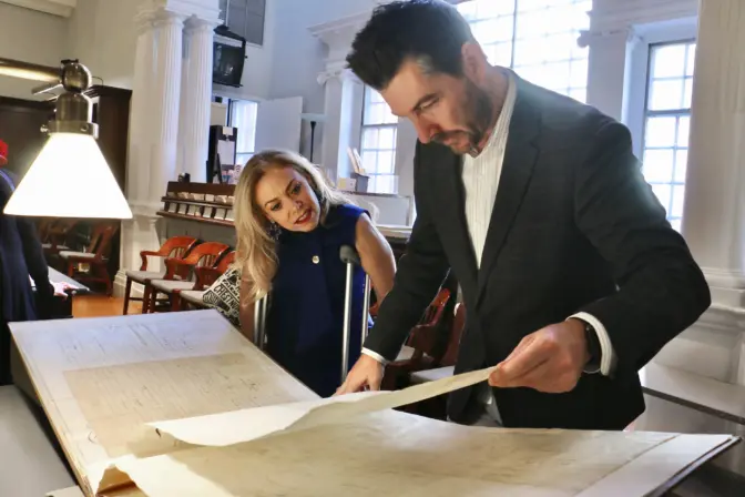 Philadelphia city representative Sheila Hess looks over some 19th century Quaker wedding certificates from the collection of the Historical Society of Pennsylvania with the society’s Chief Development Officer J.C. Hatalski.(Emma Lee/WHYY)