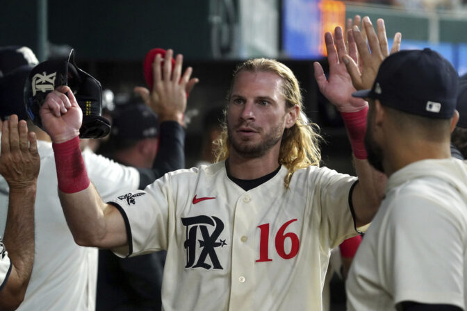 Travis Jankowski is congratulated by his Texas Rangers teammates during a game in July.