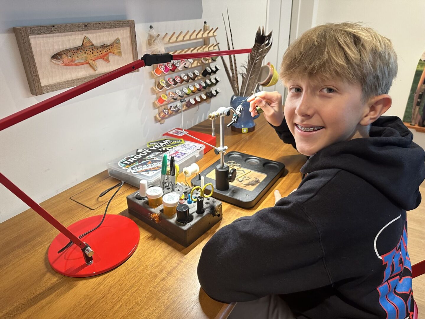 Bobby Brandt, 14, ties trout flies at his desk in his Manheim Township home.