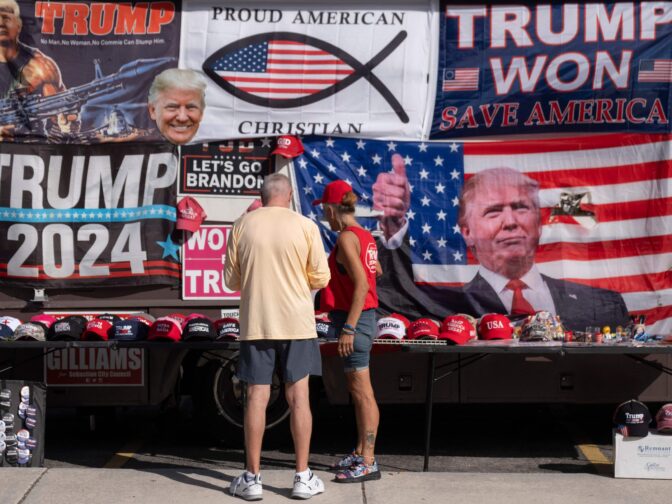 TOPSHOT - Supporters look at merchandise while arriving to hear former US President and 2024 Republican Presidential hopeful Donald Trump speak at a rally at Ted Hendricks Stadium at Henry Milander Park in Hialeah, Florida, on November 8, 2023. (Photo by Ricardo ARDUENGO / AFP) (Photo by RICARDO ARDUENGO/AFP via Getty Images)