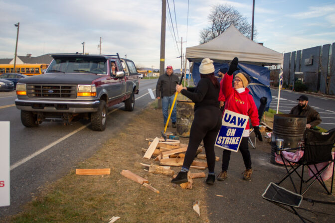 Two striking Mack Trucks workers share a "high-five" ahead of the final vote.
