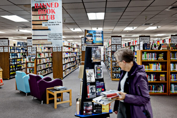 Volunteer Halli Stone of Parents Against Bad Books looks at a display for Ban Book Week for books targeted by the organization to check out in their attempts to keep obscene literature from being available at the public library outside of Idaho Falls Public Library on Wed., October 4, 2023, in Idaho Falls, ID.