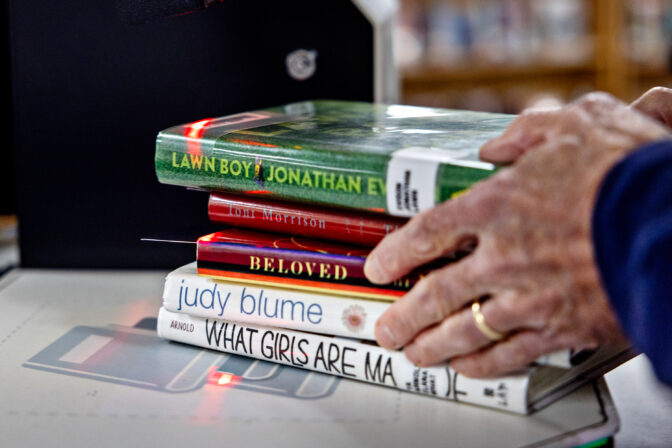 Volunteer Tom Harrison of Parents Against Bad Books looks grabs a stack of targeted books they checked out in an attempt to keep obscene literature from being available at the public library outside of Idaho Falls Public Library on Wed., October 4, 2023, in Idaho Falls, ID.