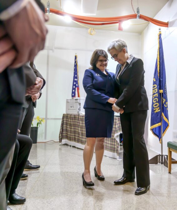 Surrounded by security, Aimee Kotek Wilson, left, and her wife, Governor Tina Kotek, prepare to enter the inaugural proceedings at the Oregon Capitol in Salem, Ore., Jan. 9, 2022.