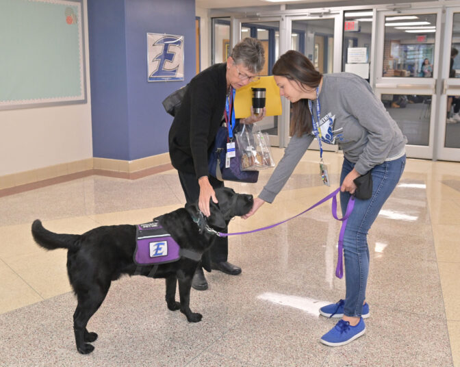 Darlene Myers, left, a substitute teacher that often works at Elizabethtown Area High School, says hello to Murphy, 4, the school's facility dog, as his owner, school counselor Amy Robinson, waits for the rush of students to enter school for the day on Friday, Oct. 13, 2023.