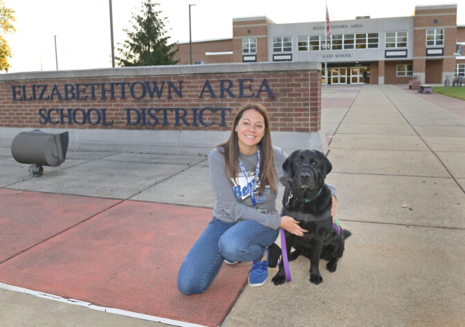 School counselor Amy Robinson kneels with her dog Murphy, 4, who is the facility dog at Elizabethtown Area High School on Friday, Oct. 13, 2023.