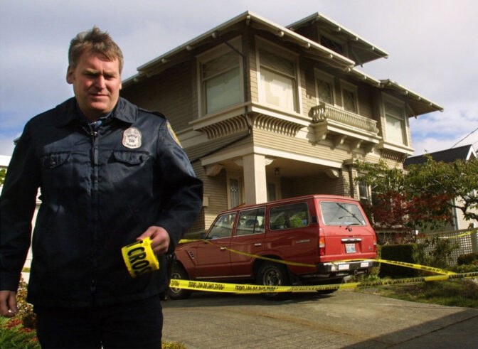 Seattle police officer William Moran tapes off the crime scene on Queen Anne on Oct. 12, 2001, where U.S. prosecuting attorney Thomas Wales was killed in his home.