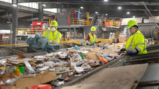 Workers along the first step of a conveyor belt remove debris by hand that doesn't belong in the recycling process at the Penn Waste facility in York on Tuesday, Nov. 21, 2023. Itmes that must be pulled from the belt include, extension cords, plastic bags, Christmas lights and clothing.