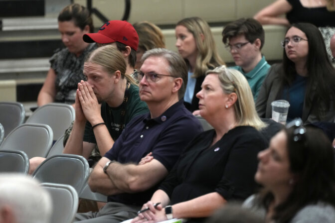 FILE - People listen during a National Transportation Safety Board investigative hearing at East Palestine High School, discussing the Feb. 3, 2023, Norfolk Southern Railway train derailment and subsequent hazardous material release and fires in East Palestine, Ohio, Thursday, June 22, 2023. Norfolk Southern railroad announced Tuesday, Dec. 5, plans to stop paying relocation aid to people displaced by the derailment right after the one-year anniversary of the crash. Railroad officials reiterated their long-term commitment to helping the town of East Palestine and the surrounding area recover. (AP Photo/Gene J. Puskar, File)