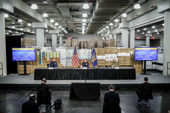 FILE - New York Gov. Andrew Cuomo, center, speaks while practicing social distancing against a backdrop of medical supplies during a news conference at the Jacob Javits Center that will house a temporary hospital in response to the COVID-19 outbreak, Tuesday, March 24, 2020, in New York. Some states that stockpiled millions of masks and other personal protective equipment during the coronavirus pandemic are now throwing the items away. (AP Photo/John Minchillo, File)