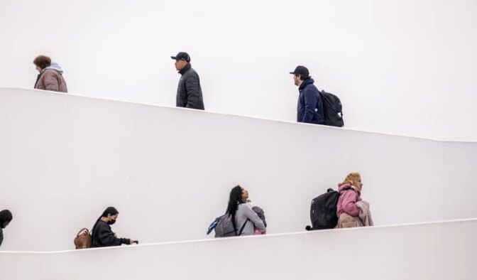 Migrants and asylum-seekers cross into the United States from Tijuana, Mexico, through the El Chaparral crossing, walking up its iconic white ramp on their way to make their asylum claim on May 12, 2023.