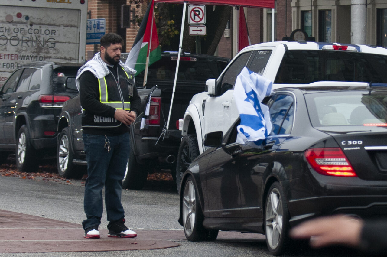 A man waves an Israel flag as he drives past hundreds gathered at the state capitol building in Harrisburg on Dec. 10, 2023 calling for a permanent cease fire in the war between Israel and Palestine. Jeremy Long - WITF